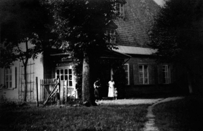Muižas dzīvojamā ēka no parka puses ap 1935. gadu.  Pie ieejas (no kreisās) Ksenija Pētersone, Lidija Pētersone un Brigita Pētersone (Foto no Brigitas Bankovskas personiskā arhīva)
